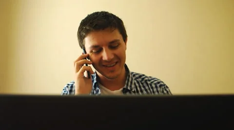 Man working on a notebook and talking on a phone Stock Footage 53316879