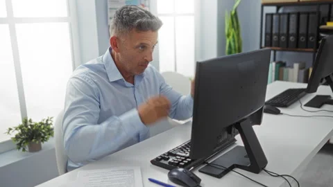 Man working in an office on a computer, showing expressions of concentratio.. Stock Footage 283550000