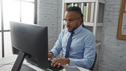 Man working in an office focused on his computer with a thoughtful expressi.. 스톡 동영상 289720436