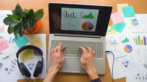 Man working at office with laptop surrounded by a lot of paperwork, top view Stock Footage 87873266