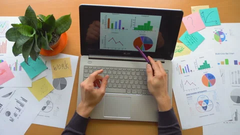 Man working at office with laptop surrounded by a lot of paperwork, top view Stock Footage 87874044