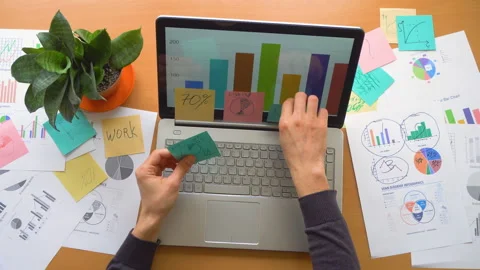 Man working at office with laptop surrounded by a lot of paperwork, top view Stock Footage 87977699