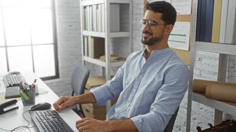 Man working in office room using computer smiling while wearing glasses and.. Stock Footage 308532767