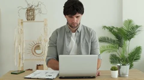 Man working in office using laptop in office. Young professional checking email Stock Photos