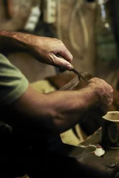 Man working in an old retro workshop with dim light. Atmospheric. Stock Photos