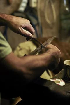 Man working in an old retro workshop with dim light. Atmospheric. Stock Photos