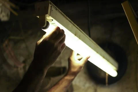 Man working in an old retro workshop with dim light. Atmospheric. Foto stock