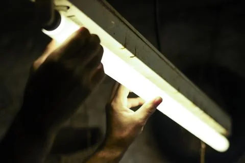 Man working in an old retro workshop with dim light. Atmospheric. Stock Photos