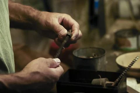 Man working in an old retro workshop with dim light. Atmospheric. Foto stock