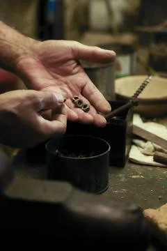 Man working in an old retro workshop with dim light. Atmospheric. Stock Photos