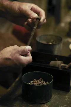 Man working in an old retro workshop with dim light. Atmospheric. Foto stock