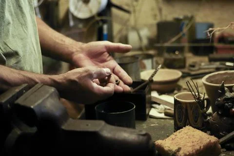 Man working in an old retro workshop with dim light. Atmospheric. Stock Photos