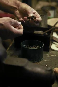 Man working in an old retro workshop with dim light. Atmospheric. Stock Photos