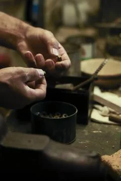 Man working in an old retro workshop with dim light. Atmospheric. Stock Photos