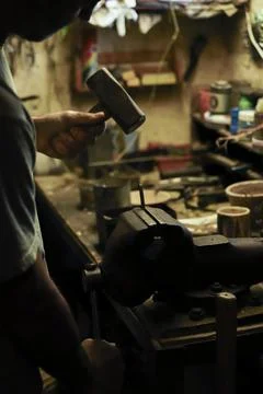 Man working in an old retro workshop with dim light. Atmospheric. Stock Photos
