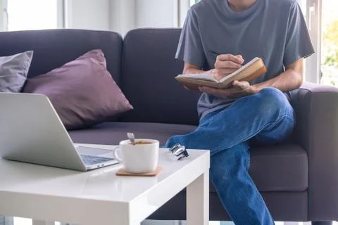 A man working or study online in the living room on the sofa. due to the spre Stock Photos