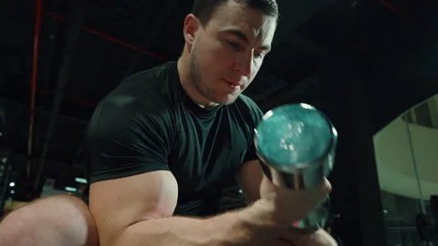 Man working out biceps muscles with dumbbell Stock Footage 148346934