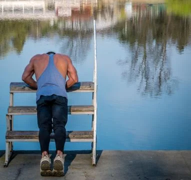 Man working out exercise in front of a lake. Stock-Fotos
