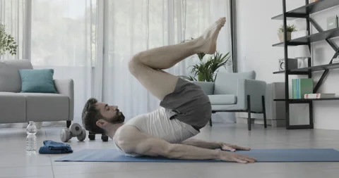 Man working out on the exercise mat at home Stock Footage 157626714