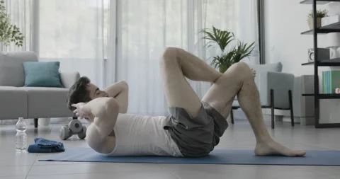 Man working out on the exercise mat at home Stock Footage 157632521