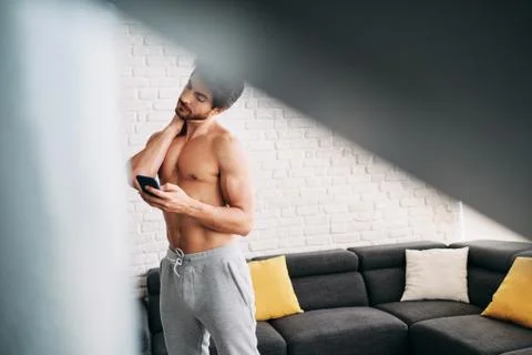 Man Working Out At Home With App On Mobile Phone Stock Photos
