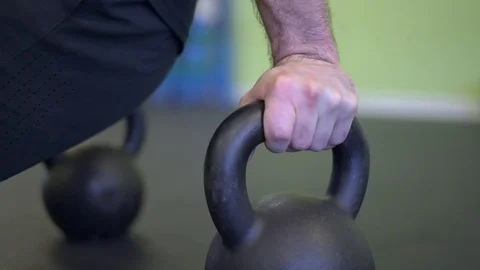 Man working out with kettle bell handles Stock Footage 73135867