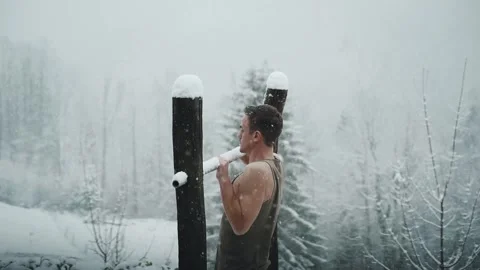 Man working out on pull up bar while snowing in winter. Vídeos de archivo 225281679
