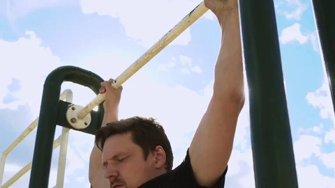 Man working out pull ups on. Blinding the sun for a second Stock Footage 78306386