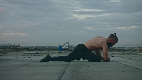Man working out on rooftop reaches up to sky Stock Footage 275594407
