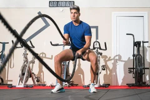 Man working out with rope in functional training fitness gym. 库存照片