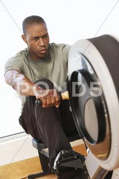 Man Working Out On Rowing Machine Stock Photos