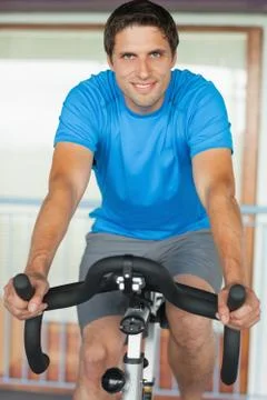 Man working out at spinning class in gym Photos