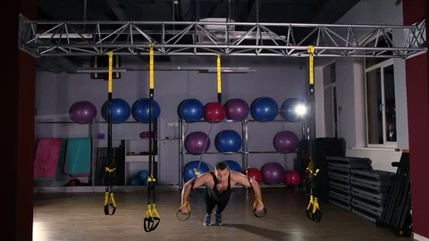 Man working out on trx in a gym Stockbeeldmateriaal 76472005