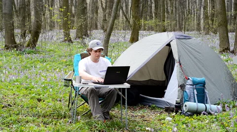 Man working outdoors in a tent camp. Stock Footage 63123144