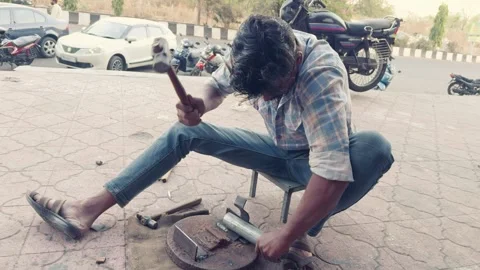 Man working outdoors with tools focused on a manual task with a motorcycle .. Stock Footage 267850355