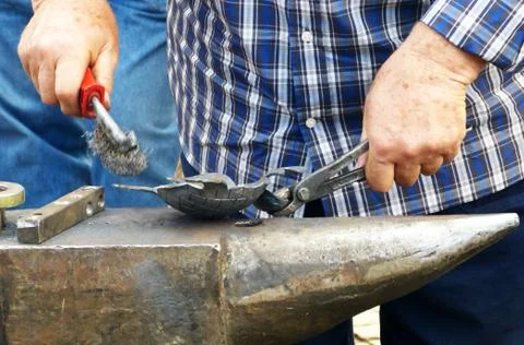 Man working over an anvil Stock Photos