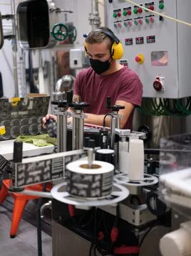 Man working packing beer cans in a factory Stock Photos