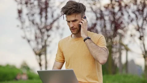 Man working on pc and disucssing business on phone Stock Footage 132728667