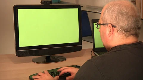 Man working on PC and laptop. Green screens. Stock Footage 32168366