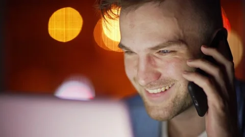 Man working on pc and talking on cell phone Stock Footage 131536645