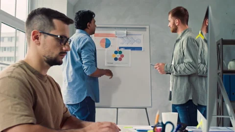 Man Working on PC in Creative Office. Team Discussing Presentation in Office Stock Footage 217837094