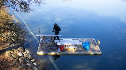A man in working on a platform on a lake Stock Photos