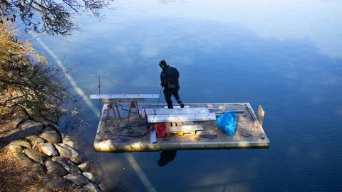 A man in working on a platform on a lake Stock Photos