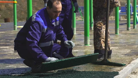 Man working on playground Rubber beads floor. Stock Footage 91729352