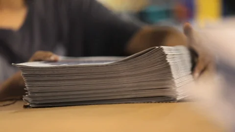 Man working at printing house sorting stacks of newspapers. Stockbeeldmateriaal 112214570