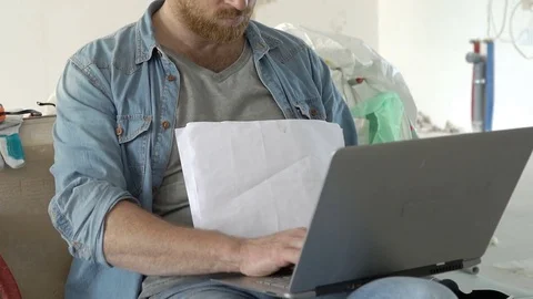 Man working on the project and using notebook in his new apartment, steadycam sh 스톡 동영상 78635056