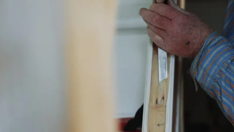 A man is working on a project, using a knife to cut a piece of wood Stock Footage 301793070