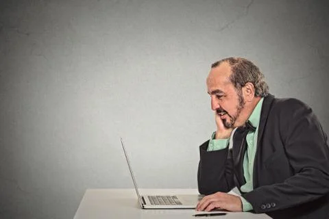 Man working reading something on his laptop computer Stock Photos