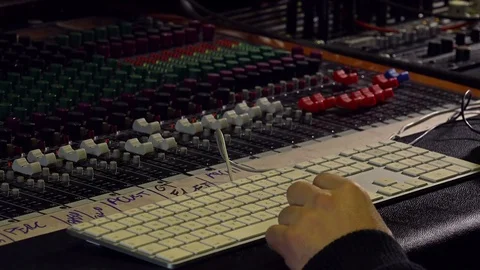 Man working in a recording studio using the mixer desk Stock Footage 70858180