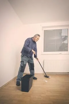 Man working on refresh of floor before new painting of apartment Stock Photos